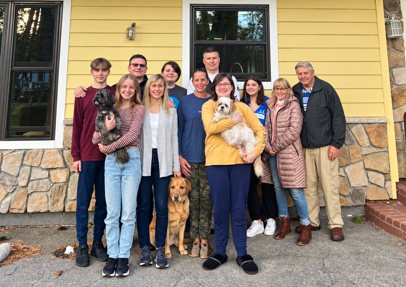 Eric Barrett’s family gathered outside a yellow house, with his dad on the right.